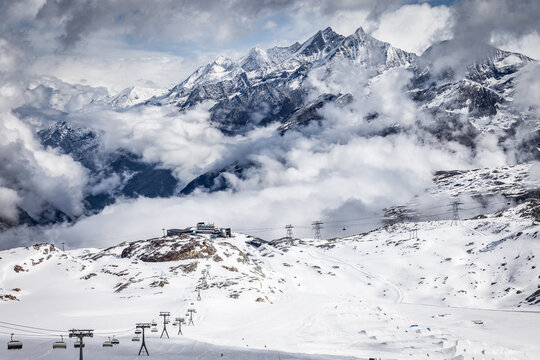 View of the Matterhorn mountain peak rising above snow-covered slopes and ski lift infrastructure in the Swiss Alps near Zermatt, Valais, Switzerland.