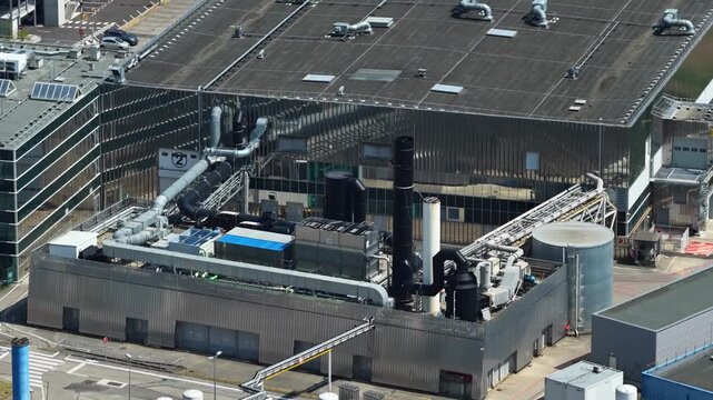 Bernin, Isere - France - August 1 2026: Close aerial view of technical buildings, exhaust systems, pipes and industrial utility infrastructure at the Soitec semiconductor manufacturing complex