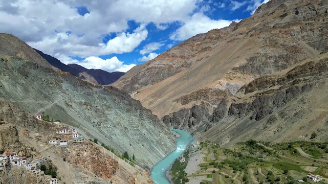Aerial view of Phukthal Gompa monastery perched on a cliffside above the turquoise Lungnak River in the Zanskar mountains, Phugtal, Himachal Pradesh, India.