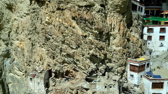 Aerial view of Phukthal Gompa monastery built into the cliffside, showing traditional stone architecture and rugged Himalayan rock formations in Phugtal, Himachal Pradesh, India.