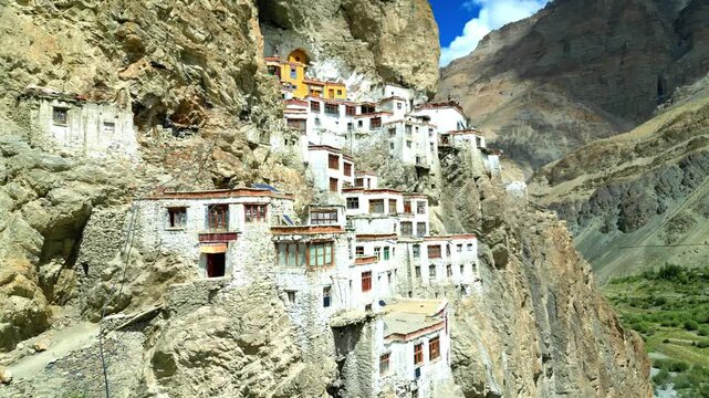 Aerial view of Phukthal Gompa monastery built into the cliffside above a river in Phugtal, Himachal Pradesh, India.