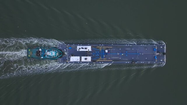 Aerial view of a tugboat pushing a barge along the Hudson River in Highlands, New York, United States.