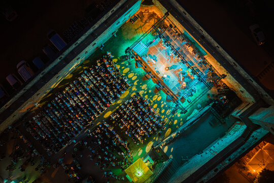 Svetvincenat, Croatia - 05 July 2026: Aerial view of an evening concert in the Morosini-Grimani Castle courtyard, featuring a stage with green lighting and rows of seated audience members.