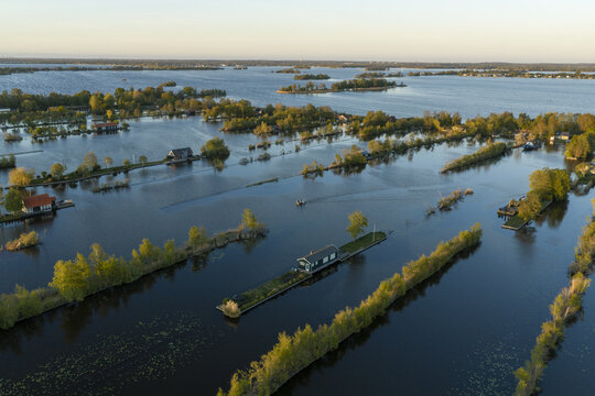 Aerial view of Scheendijk featuring small islands with houses surrounded by water and lush greenery in Breukelen, Utrecht, Netherlands.