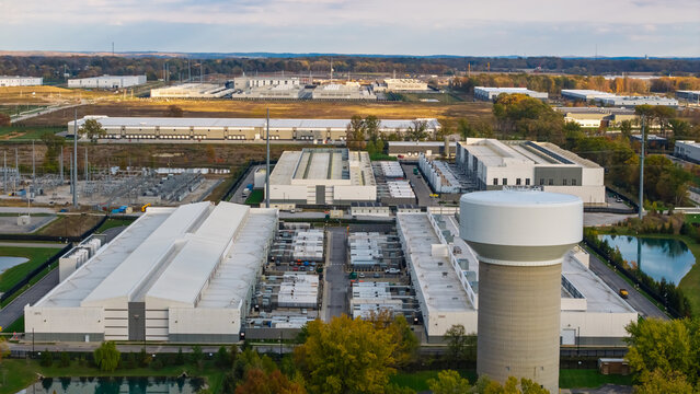 Aerial view of a large data center complex with industrial buildings, cooling infrastructure, and a prominent water tower in New Albany, Ohio, United States.