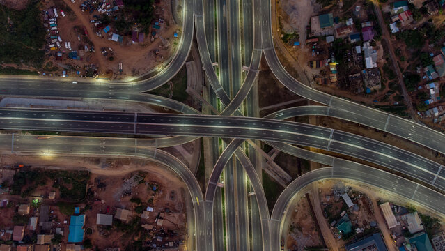 Aerial view of the illuminated Pokuase Interchange at night, featuring complex multi-level highway ramps and surrounding urban development in Ga North Municipal, Greater Accra Region, Ghana.