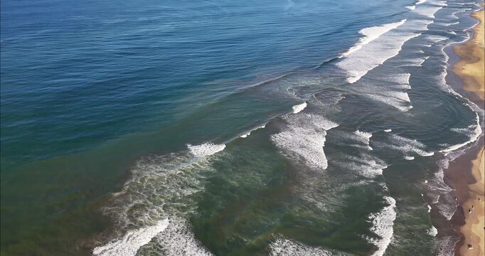 Aerial view of the coastline at Acapulco Diamante with rolling waves crashing onto the sandy beach in Acapulco de Juarez, Guerrero, Mexico.