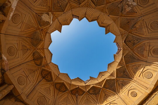 View of the intricate stone dome ceiling with a central circular opening at the historic Makli Necropolis in Thatta, Sindh, Pakistan.