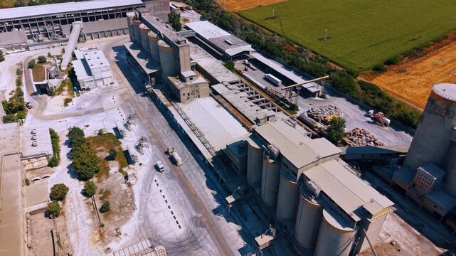 Trucks move by the territory of a large modern plant. Drone footage approaching the tanks located in the industrial area.