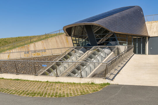 View of De Heining pumping station with its modern architecture and large Archimedean screw pumps, set against a clear blue sky in Marrum, Friesland, Netherlands.