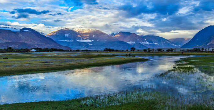 Scene featuring panorama of Himalayas and landscape of Nubra valley on sunset. Hunber, Nubra valley, Ladakh, India