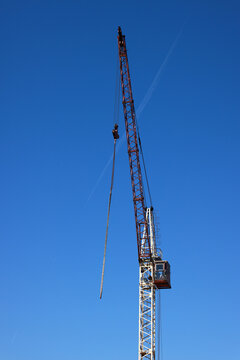 View of a tall construction crane reaching towards a clear blue sky in Vilnius, Vilnius County, Lithuania.