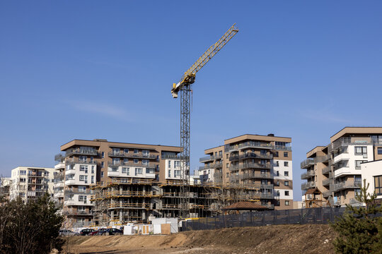 View of modern apartment buildings under construction with a tall tower crane against a clear blue sky in Vilnius, Vilnius County, Lithuania.