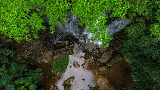 Aerial view of Oboadaka Falls cascading over rocky terrain surrounded by lush green tropical foliage in Aburi, Eastern Region, Ghana.