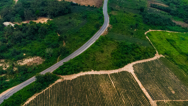 Aerial view of the winding road through the lush green landscape and agricultural fields near Pokrom in Aburi, Eastern Region, Ghana.