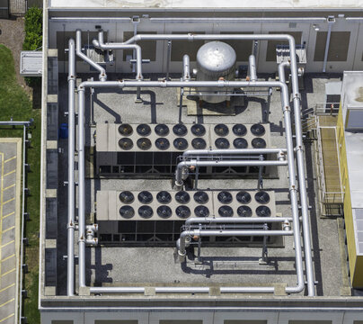 Aerial view of a data center cooling system featuring large fan arrays, industrial piping, and a chilled water dry cooler unit on a rooftop in Franklin, Tennessee, United States.