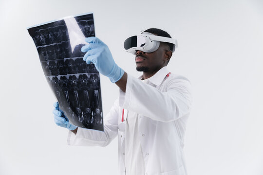 African male doctor examining MRI scan revealing spinal of with vr headset in modern healthcare setting