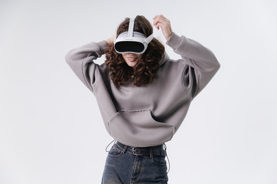 Young asian female enjoying vr experience wearing casual grey hoodie