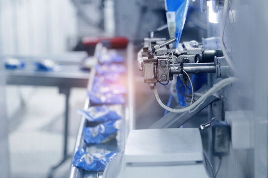 Automated packaging line transporting bags through production, milk food industry