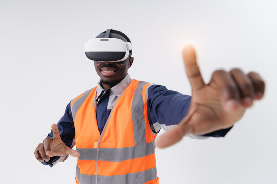 African American male young adult in safety vest using virtual reality headset, touches web interface with sunlight