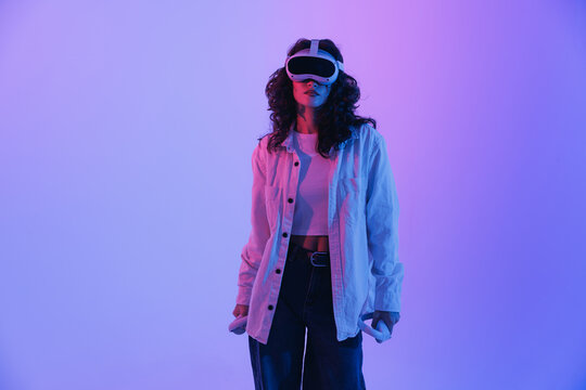 Young asian female in virtual reality headset with neon lighting