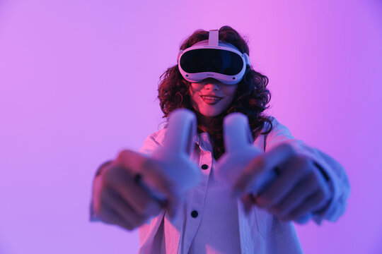 Young asian female engaged in virtual reality with vr headset and controllers. Concept gaming immersive technology