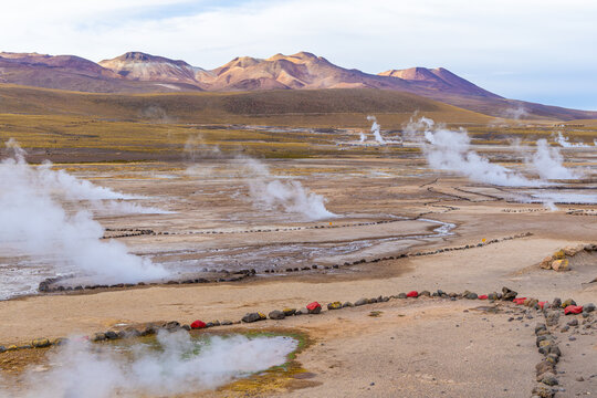 View of El Tatio geysers with steam rising from geothermal vents in the arid landscape of the Andes mountains in Antofagasta, Chile.