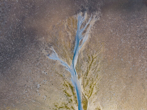 Aerial view of a dry riverbed with intricate branching patterns and sediment deposits in the arid landscape of Lower King, Western Australia, Australia.