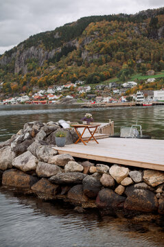 Idyllic Norwegian village nestled by a fjord with a scenic waterfront seating area
