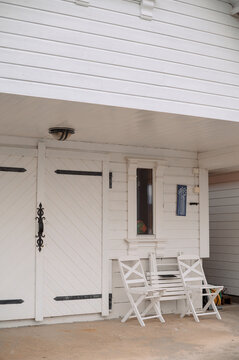 Charming white wooden building with chairs and decorative elements in Norway