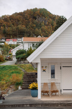 Cozy white house with autumn foliage and scenic mountain backdrop in Norway