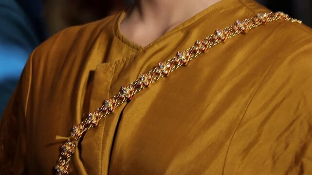 Thai classical Khon performer getting dressed and adjusted in traditional ornate costume before performance In Bangkok.