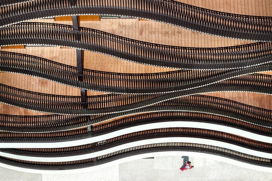 Aerial view of modern architectural curves with wavy black railings and wooden decking and a person walking below in Belgrade, City of Belgrade, Serbia.