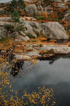 Autumnal Norwegian landscape with rocky terrain and reflective water