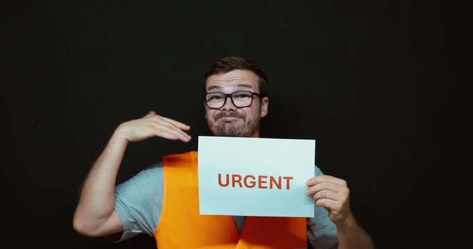 Man holding an "URGENT" sign while making a hand gesture to emphasize immediate attention. Ideal for deadlines, priority tasks, emergency communication, and business urgency concepts.