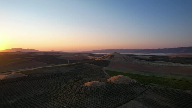 Aerial view of Lydian Tumuli of Bin Tepe at sunset with rolling hills and agricultural fields Salihli, Manisa, Turkiye.