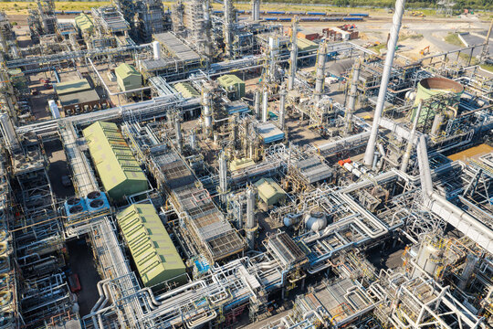 Aerial view of an industrial oil refinery complex featuring intricate networks of pipes, storage tanks, and processing units in the United Kingdom.