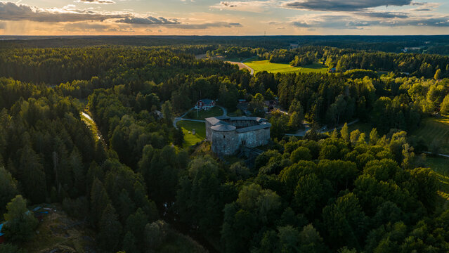 Aerial view of Raseborg Castle ruins set within a lush forest landscape at sunset Raseborg, Uusimaa, Finland.