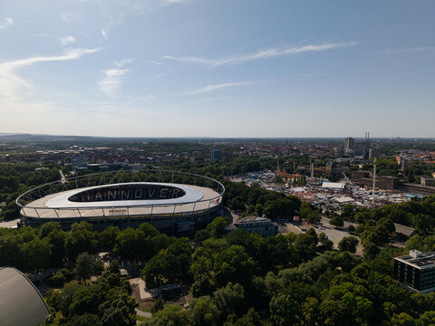 Hanover, Germany - 12 July 2026: Aerial view of Heinz von Heiden Arena surrounded by lush green trees and urban landscape.