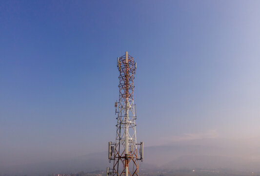 Aerial view of a telecommunications tower standing against a clear blue sky in Kedungbanteng, Central Java, Indonesia.