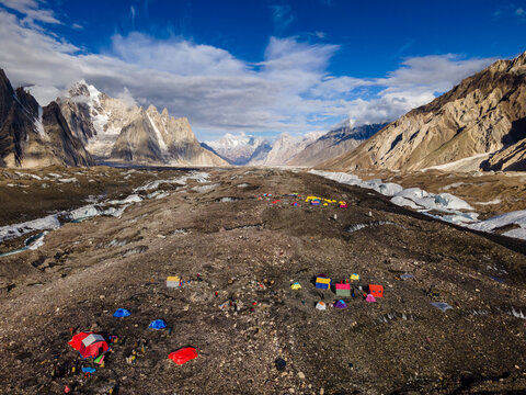 Aerial view of Concordia campsite surrounded by rugged mountain peaks, glaciers, and rocky terrain in Gilgit Baltistan, Pakistan.