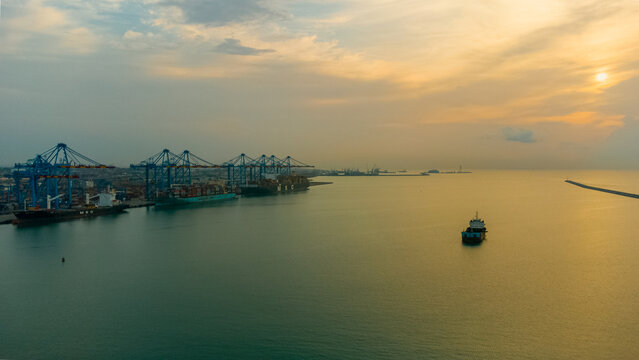 Aerial view of MPS Terminal 3 at the Port of Accra with large container ships docked by gantry cranes under a golden sunset sky in Accra, Greater Accra, Ghana.