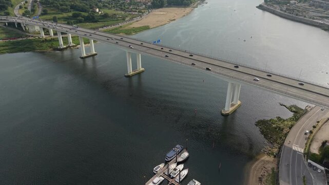 Aerial view of Ponte do Freixo bridge spanning the Douro River with traffic and boats docked below in Porto, Porto, Portugal.