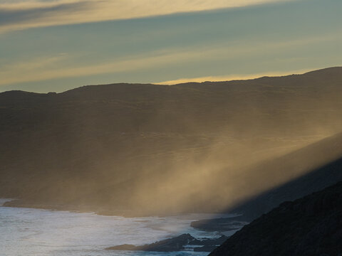Aerial view of the Blowholes at Torndirrup National Park, featuring rugged coastal cliffs, crashing waves, and golden light in Torndirrup, Western Australia, Australia.