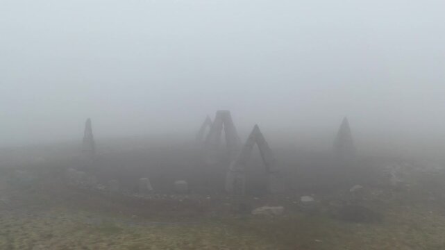 Aerial view of Arctic Henge surrounded by thick fog and rocky terrain in Raufarhofn, Nordurthing, Iceland.
