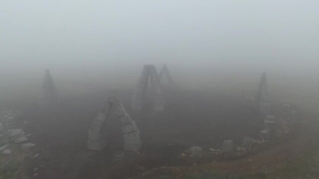 Aerial view of the Arctic Henge monument surrounded by dense fog and rocky terrain in Raufarhofn, Nordurthing, Iceland.