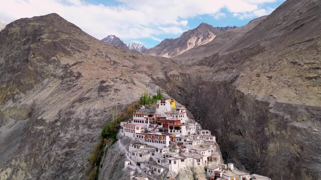 Aerial view of Diskit Monastery perched on a rocky cliffside surrounded by the rugged Himalayan mountains in Diskit, Ladakh, India.