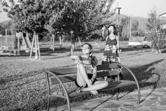 Family observing solar eclipse in park captured in dramatic black and white