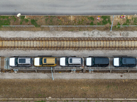Aerial view of new cars loaded on a freight train for transport along railway tracks Mszczonow, Masovian Voivodeship, Poland.