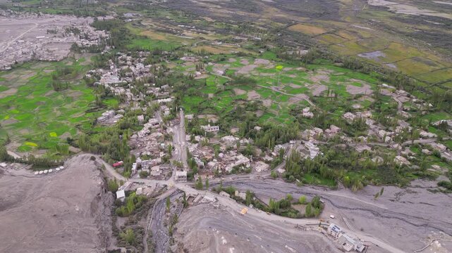 Aerial view of Diskit Monastery surrounded by green fields and rugged mountains in the valley of Diskit, Ladakh, INDIA.